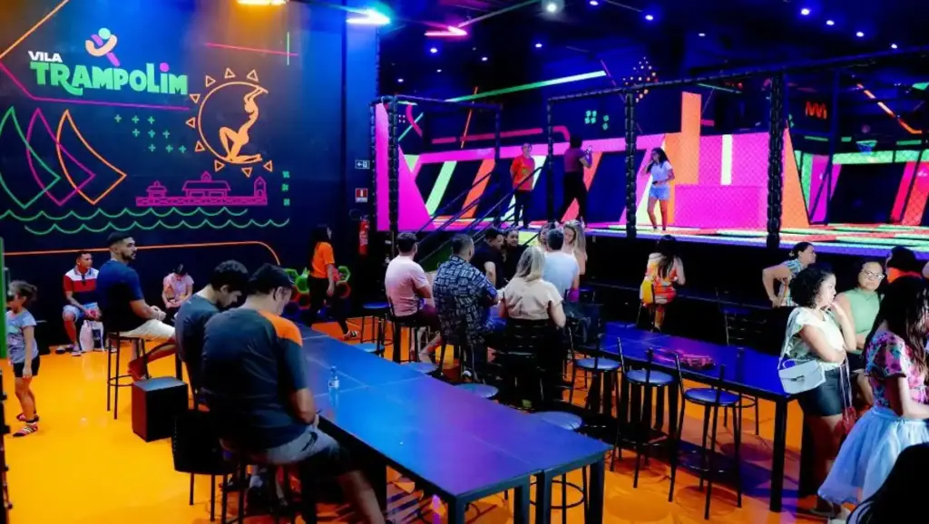 Famílias e crianças aproveitando a atração Vila Trampolim com área de trampolins, divirta-se com segurança e entretenimento para todas as idades.