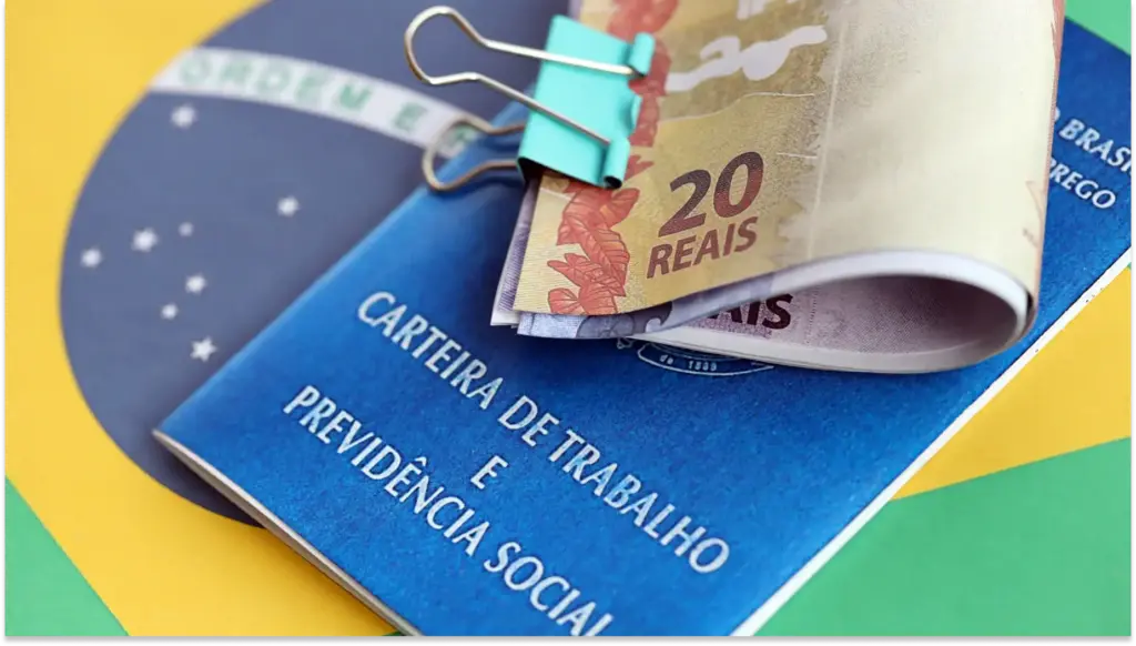 Documentos relacionados a carteira de trabalho e previdência social com dinheiro em papel em cima, simbolizando Segunda Parcela do 13 salário.