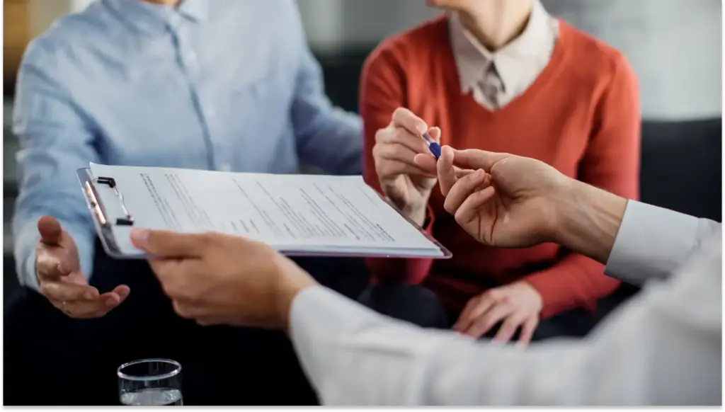 Chefe entregando uma ficha dos novos valores do Seguro desemprego a uma funcionária.
