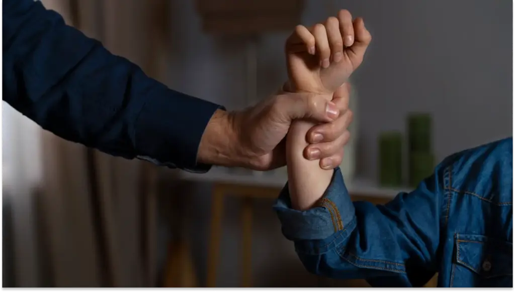 Imagem de confronto físico, com as mãos entrelaçadas e uma luta de força, representando assédio sexual.