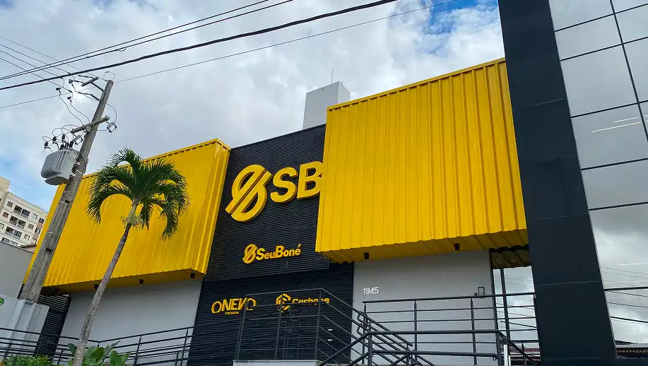 Fachada de uma loja do Banco Santander (Santander Brasil), com a fachada em cores amarelo e preto, destacando o logotipo do banco e uma placa com o endereço 1945.