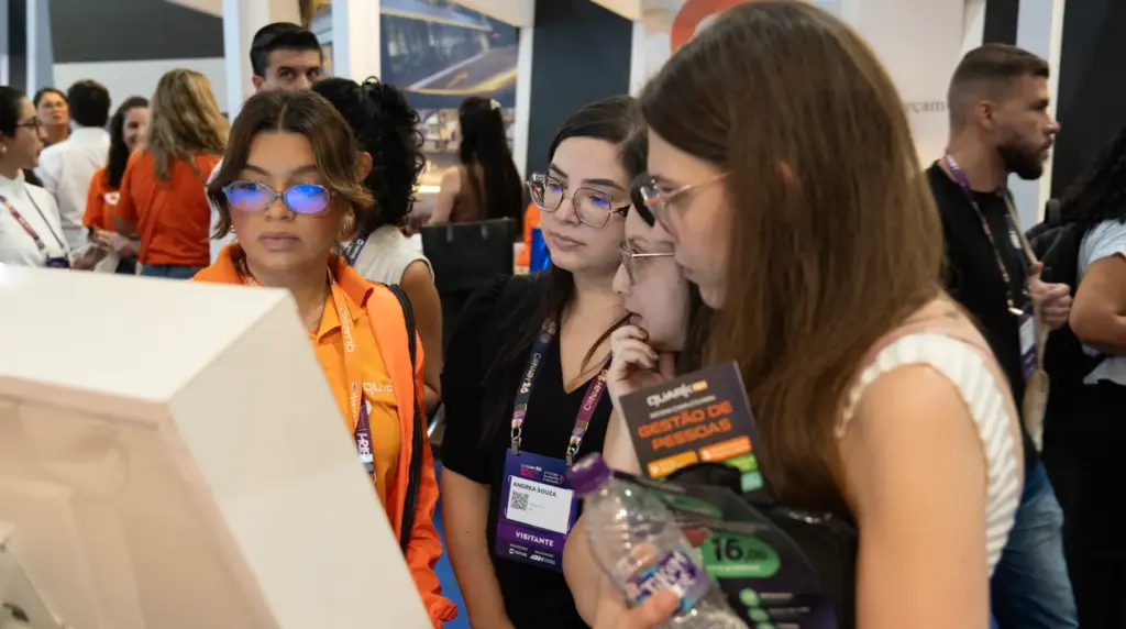 Pessoas conversando e visitando estande em evento de RH no qual QuarkRH participa da 52ª edição do CONARH em SP, em ambiente de feira e networking