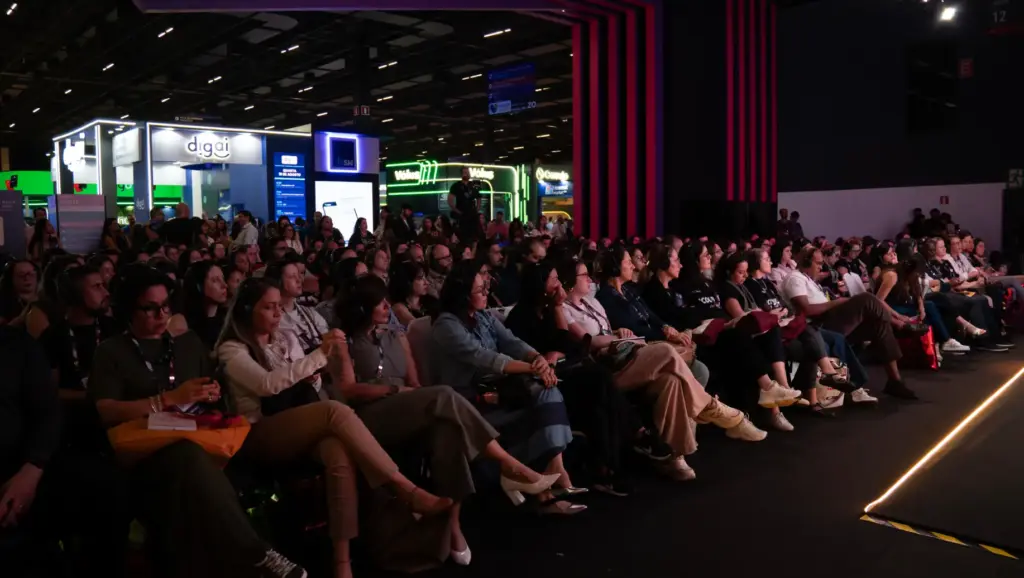 CONARH 2026: plateia lotada em um evento corporativo em auditório, com pessoas sentadas e luzes de palco ao fundo, em ambiente de feira