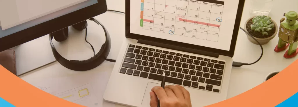 A imagem mostra um computador e um laptop com foco em um calendário de feriados e anotações em um papel. Ideal para conferir o calendário de feriados em 2025.