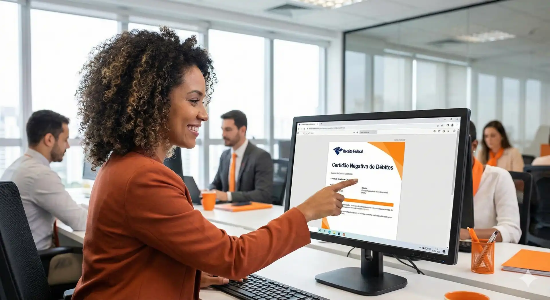 Mulher acessando o portal do e-CAC no computador em sala de reunião profissional, explicando questões fiscais com documentos na tela.