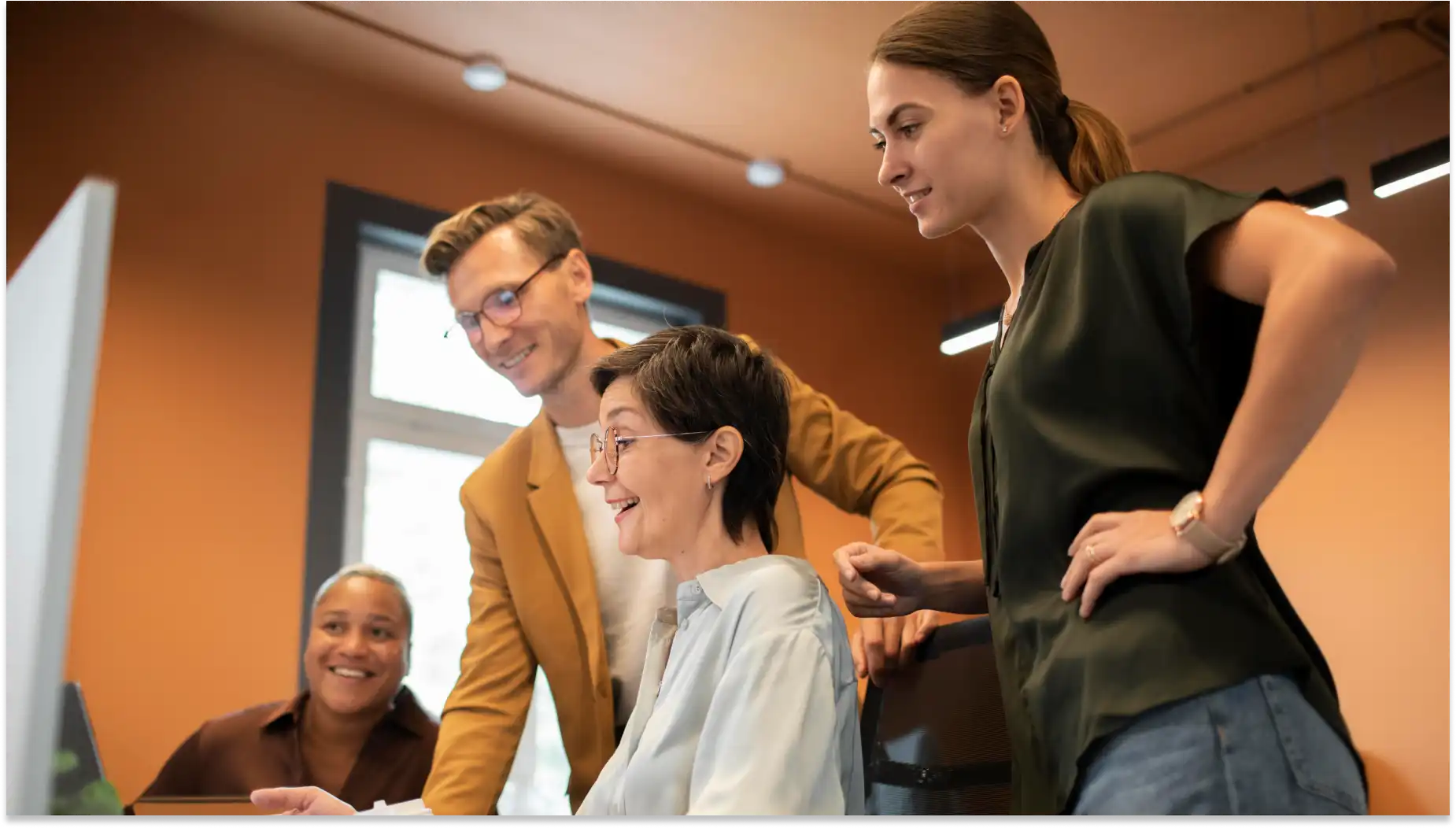 Grupo de profissionais de tecnologia colaborando em um escritório, discutindo um projeto sobre qualificação coletiva de maneira entusiasmada e engajada.