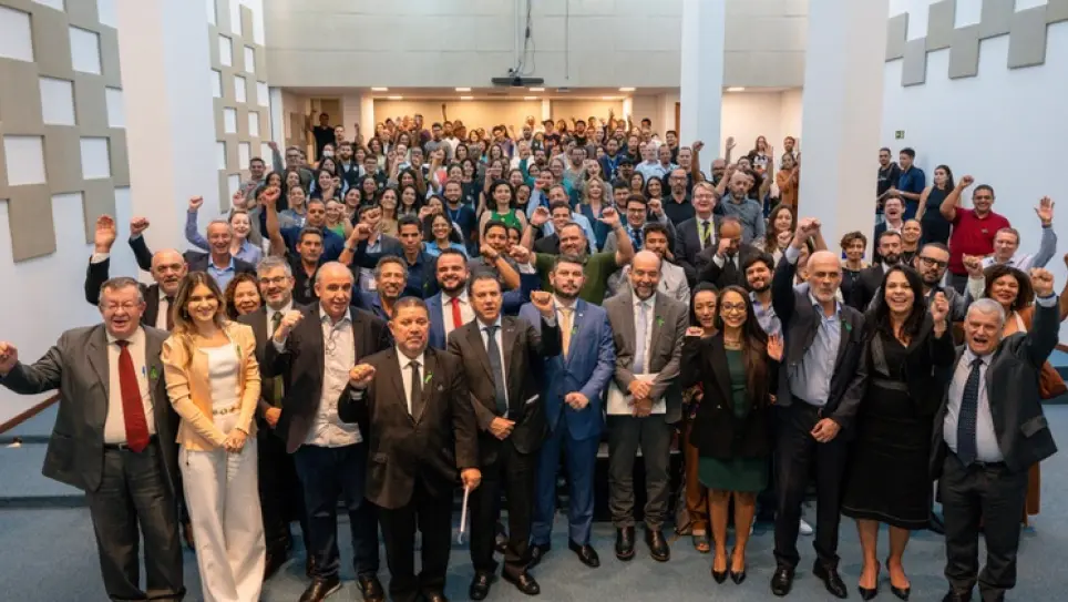 Auditório cheio com dezenas de profissionais reunidos no lançamento da Canpat 2026, muitos com o braço erguido em gesto de mobilização, representando o lançamento de campanha nacional voltada à prevenção de riscos psicossociais e à promoção da saúde mental no trabalho.