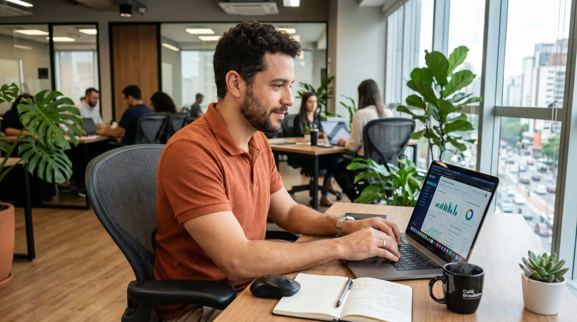 Homem trabalhando em um escritório moderno com notebook aberto mostrando um painel e gráficos de dados, enquanto analisa relatórios; conceito de melhorias de abril com mais controle e rastreio.