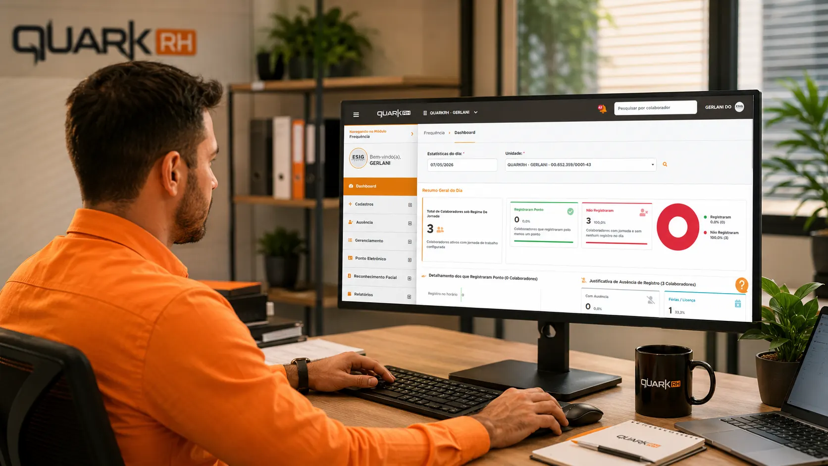 Homem com camisa laranja trabalhando em escritório, usando computador com dashboard de RH da Quark (Quark RH) e indicadores de desempenho na tela.